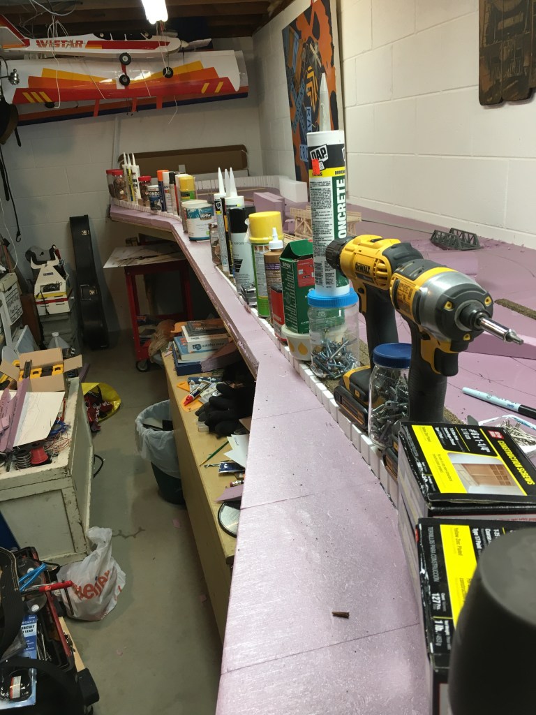 Foam risers are being glued down and weighted so that they dry secured to the baseboard.