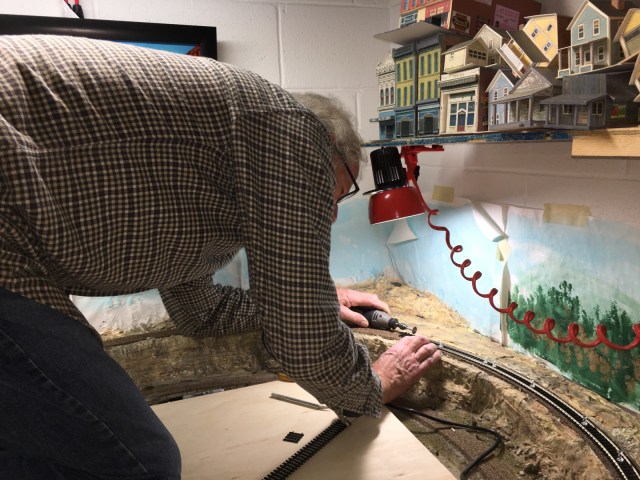 Using a Dremel tool to cut rails on a curve.