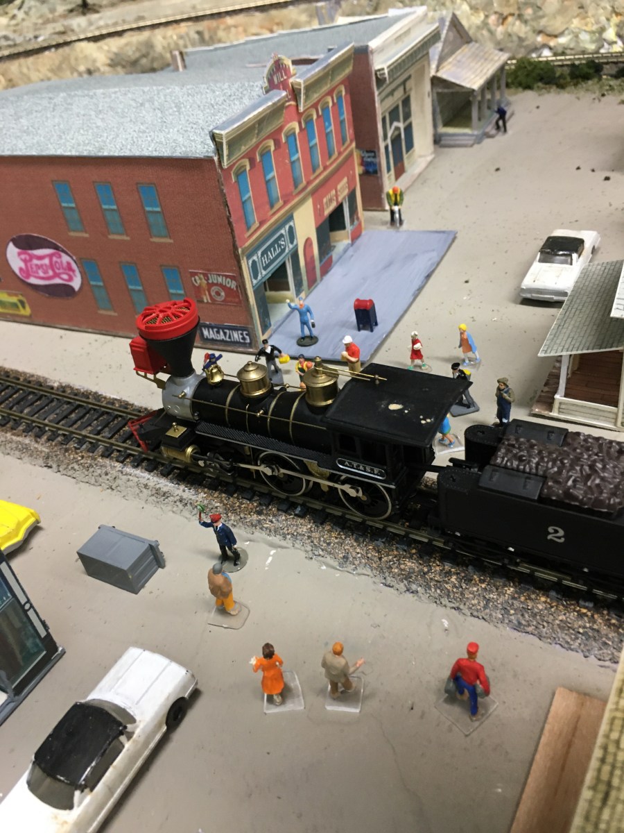 Train engine, people, buildings, cars, streets