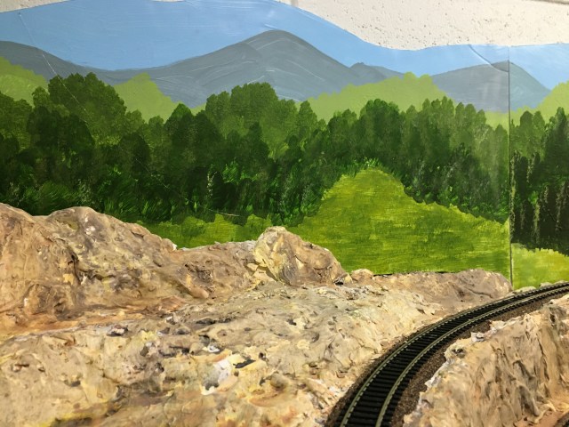 Train track, rocks, trees, mountains