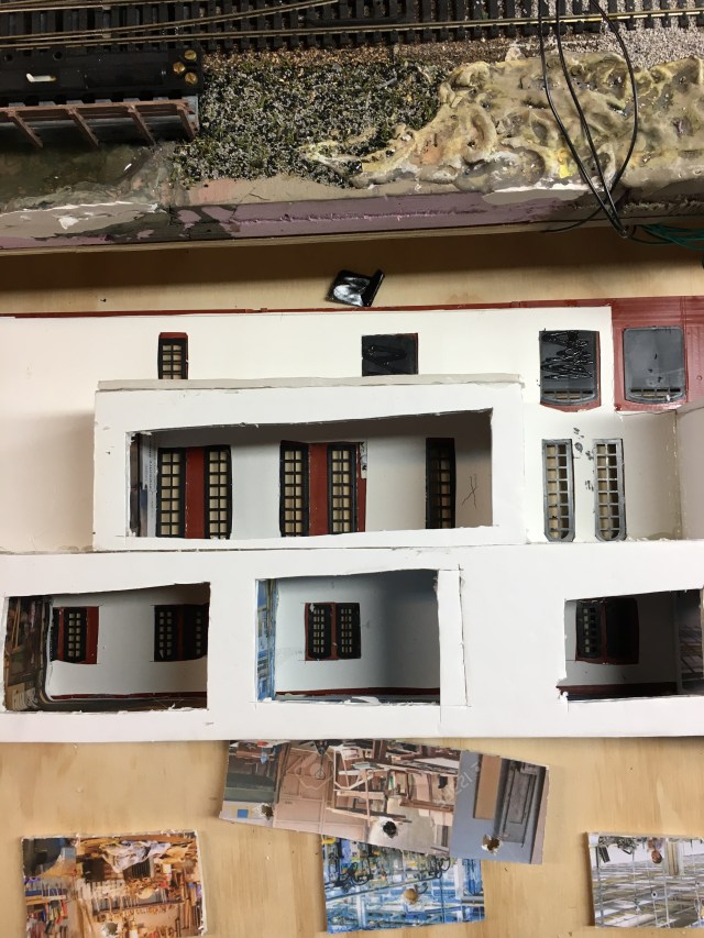 Boxes made of foam board containing photos of factory scenes