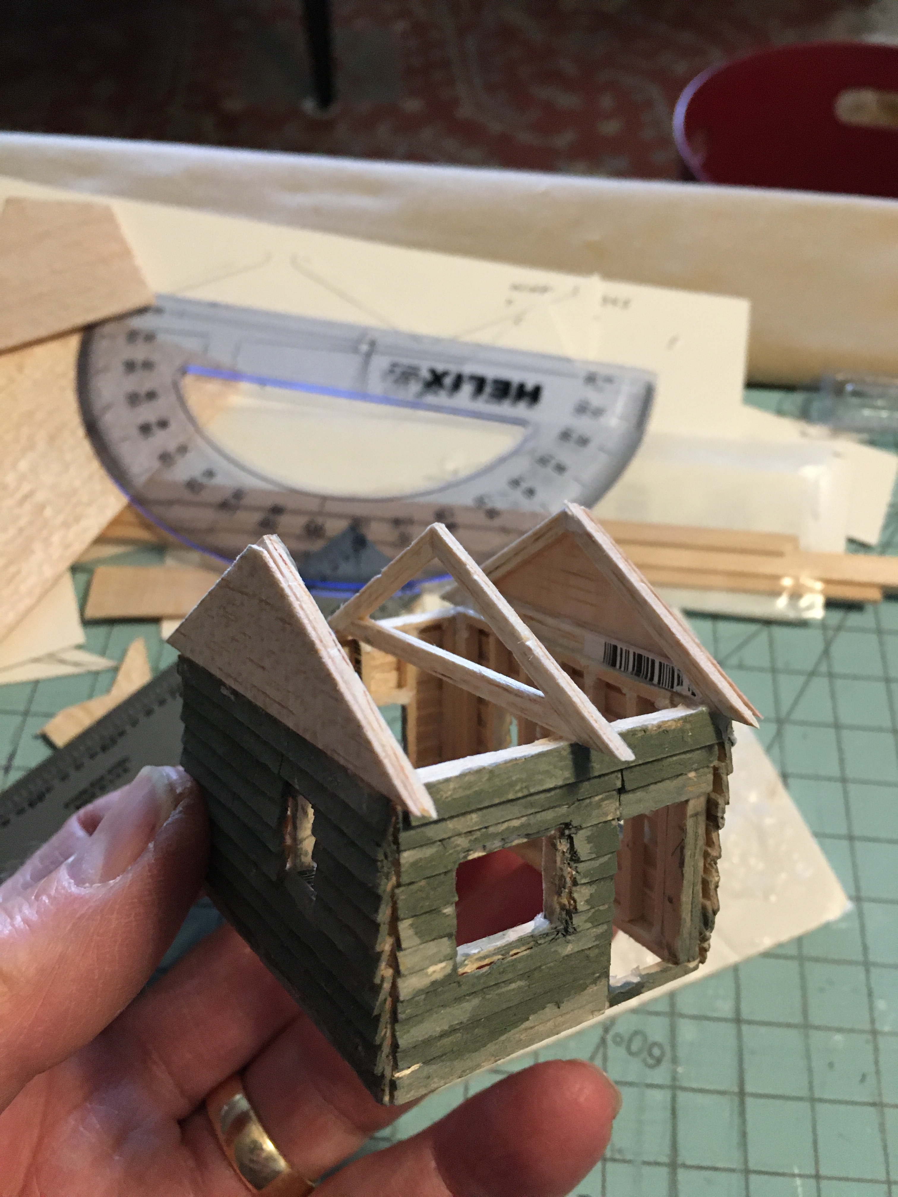 Front view of very small cabin with front door and window. Ready for roof planks.