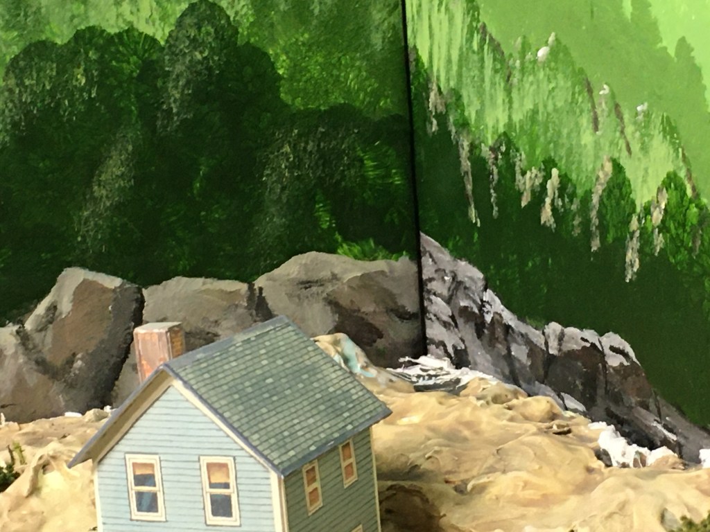 Acrylic paint backdrop showing trees and rocks with light source.