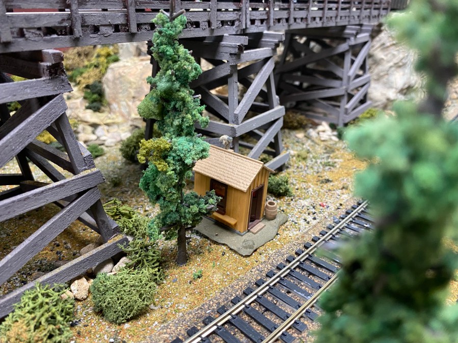 Train track, bridge, shed, trees, rocks
