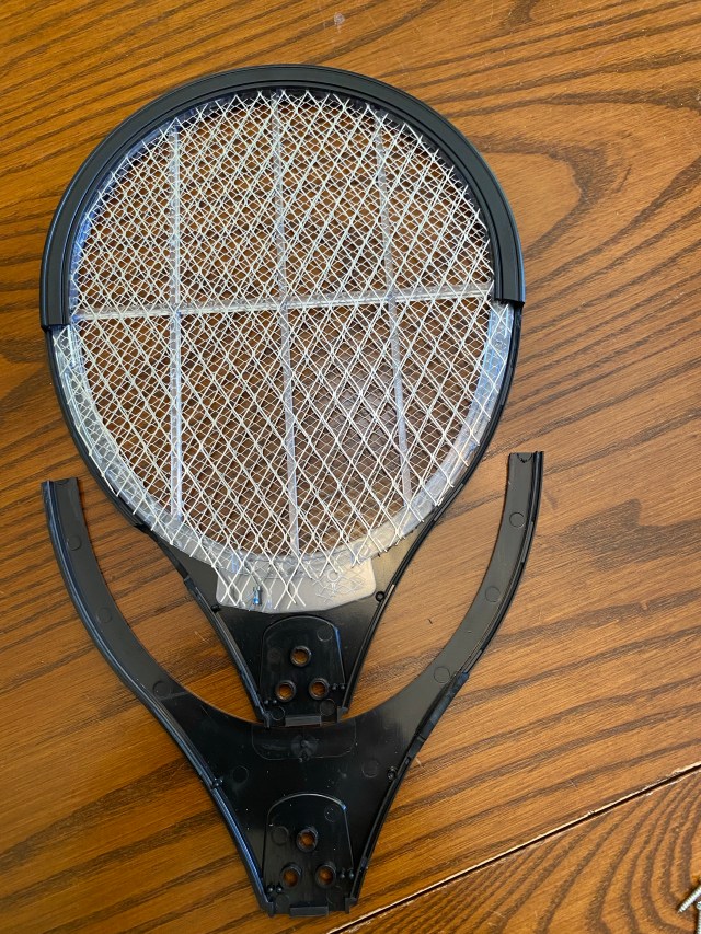 Electric bug zapper wand wires exposed.