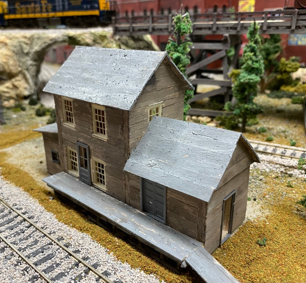 Two story painted balsa structure near tracks.