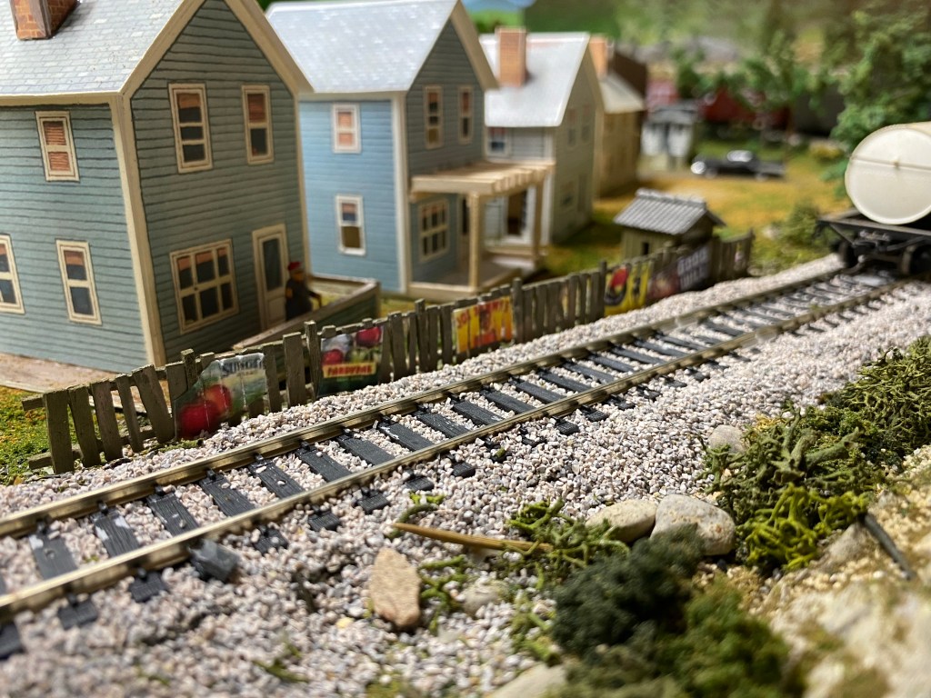 Picket fences in back yards along railroad track.