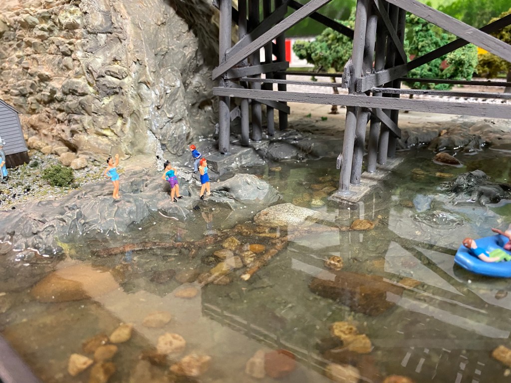 Clear Maple Valley River, girls standing on the bank, boaters.