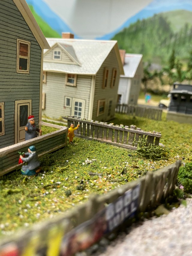 Fenced yards with people behind homes on First Street.