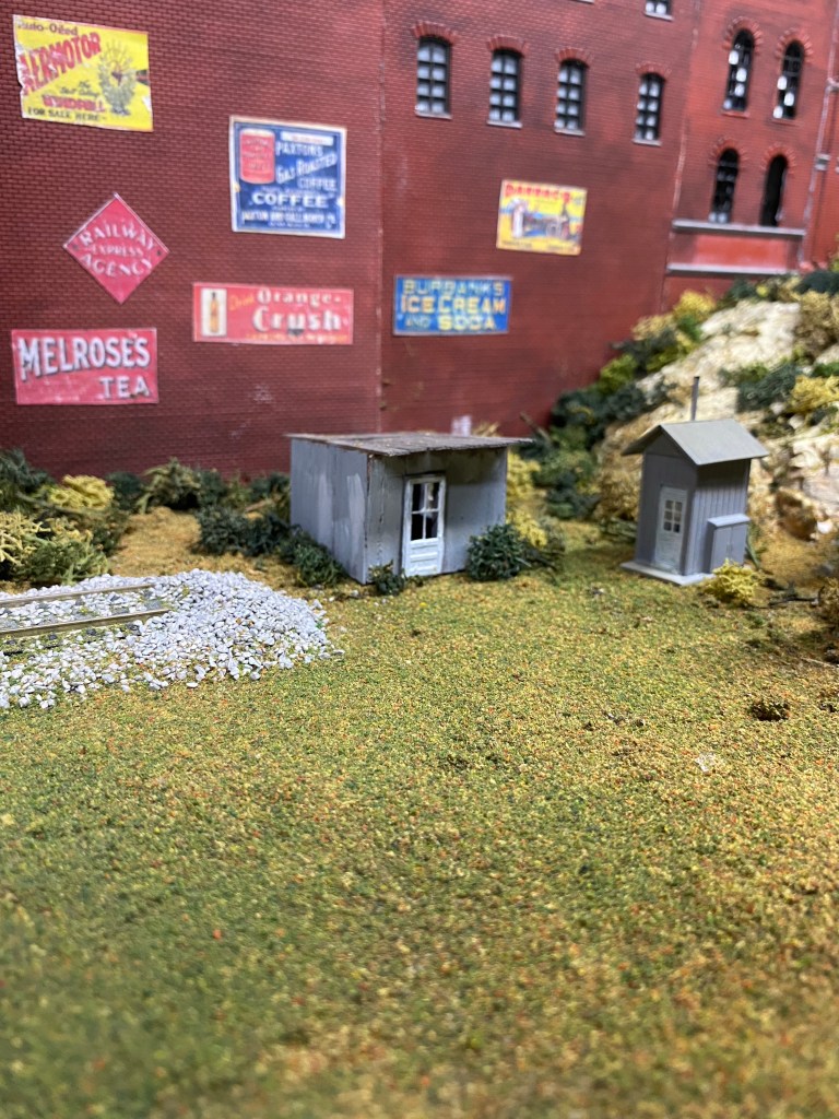Two small sheds near the end of the track.  Maple Valley Manufacturing in the background, delivers goods to retailers.