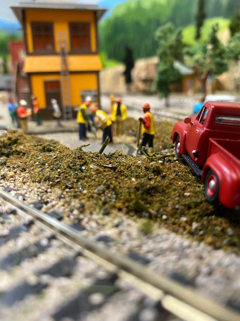 Red truck on a pile of dirt, men working to recover bones and repair watermain.  