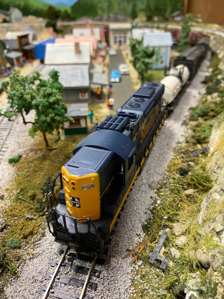 Freight train, houses, people and cars.