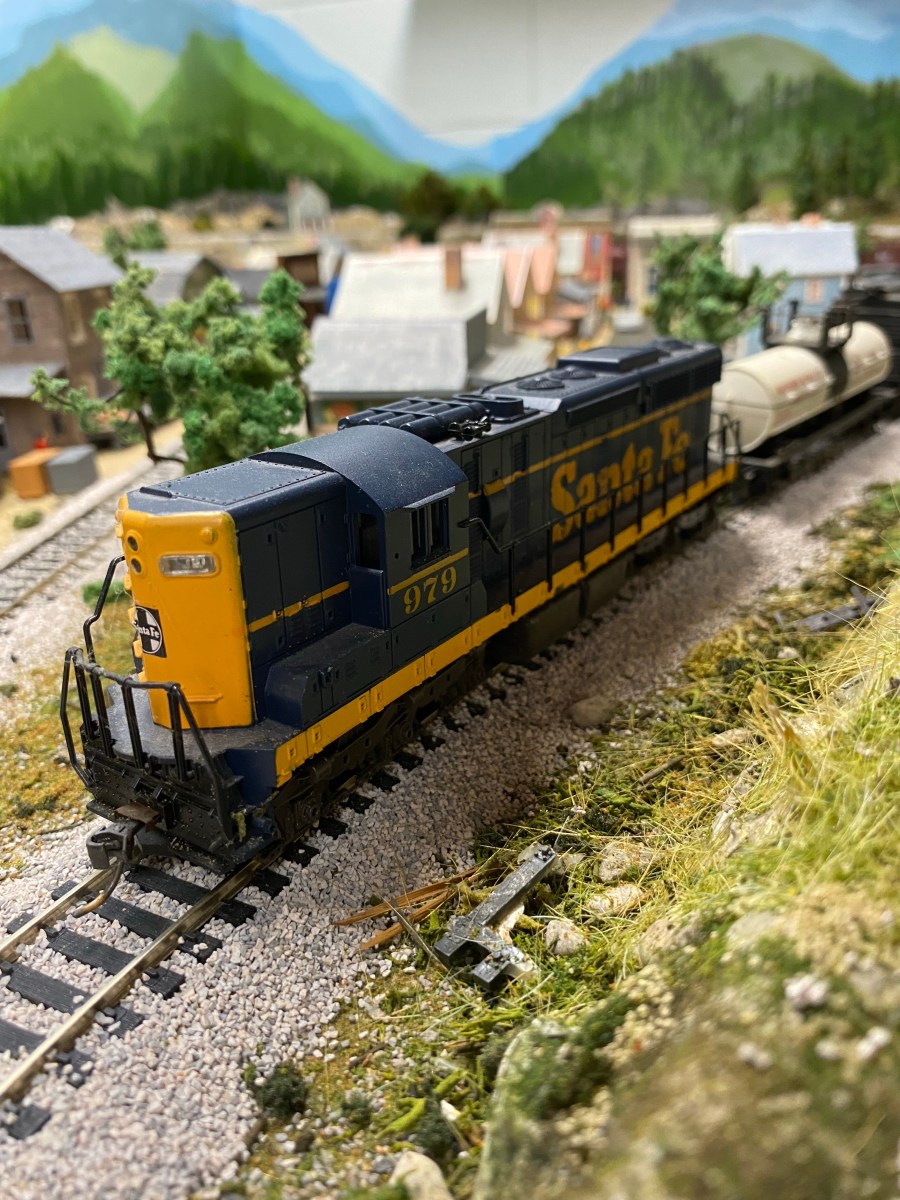 Santa Fe diesel, tank car, houses.