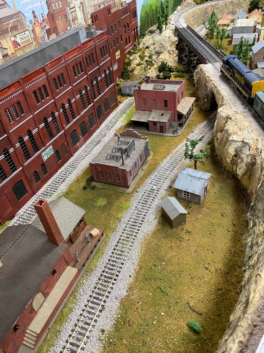 Factory buildings, sheds, tracks, mountain ridge, train