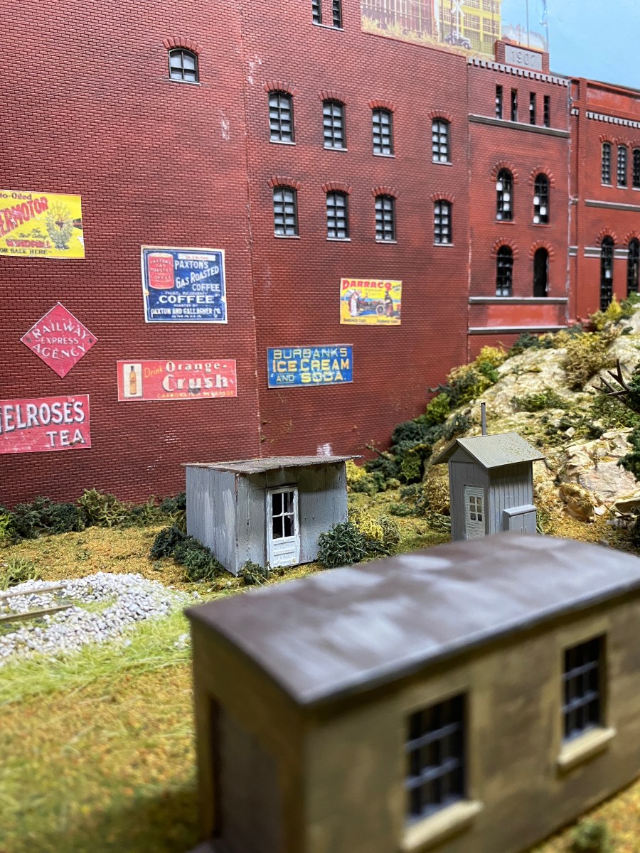 Factory building, sheds, hills, track