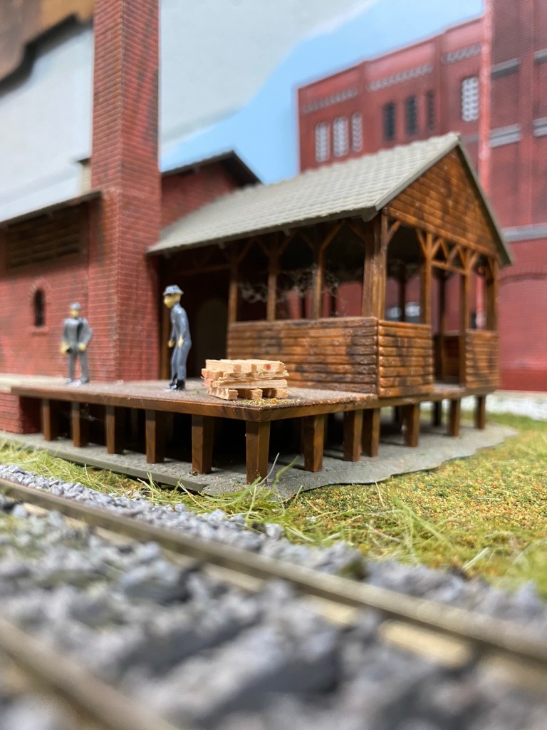 Track, building, deck, men are working at the factory dock.