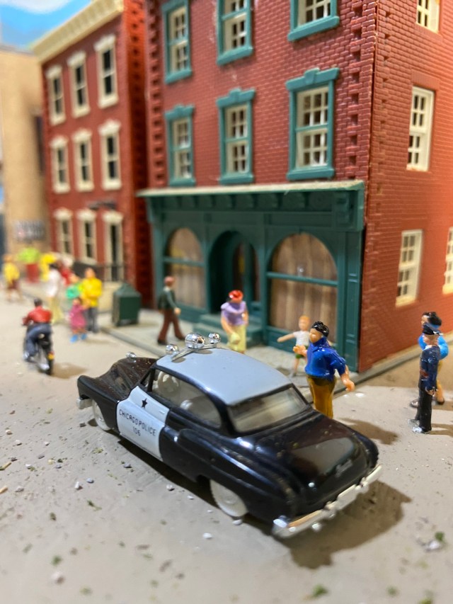 Police car, buildings, people
