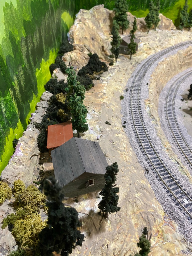 Trees, cabins, rocks, back drop, tracks