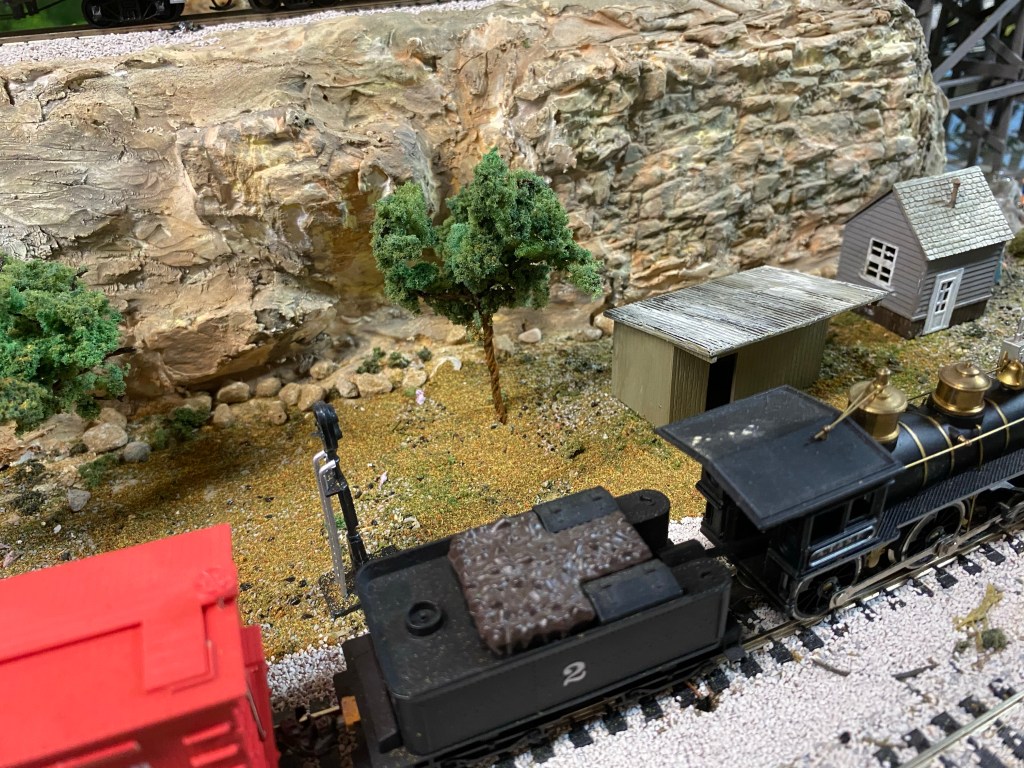 Old General locomotive, trees, sheds, rocks