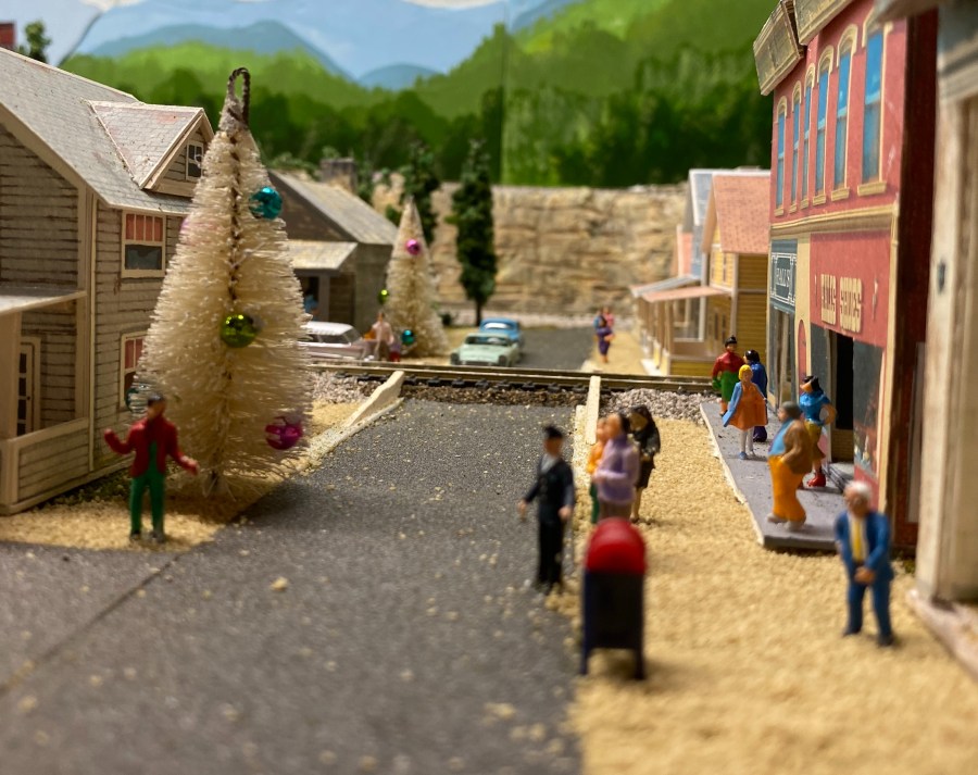 Streets, people, cars, hills, trees, buildings, Christmas tree