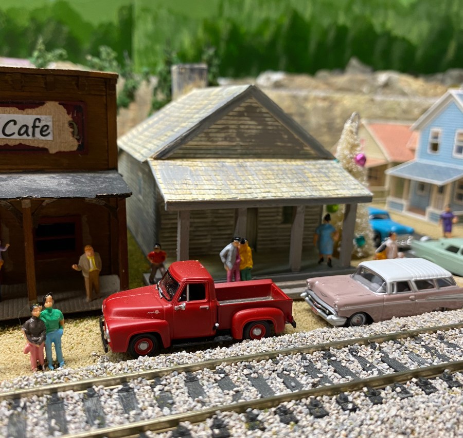 Red truck, cars, stores, track, people,