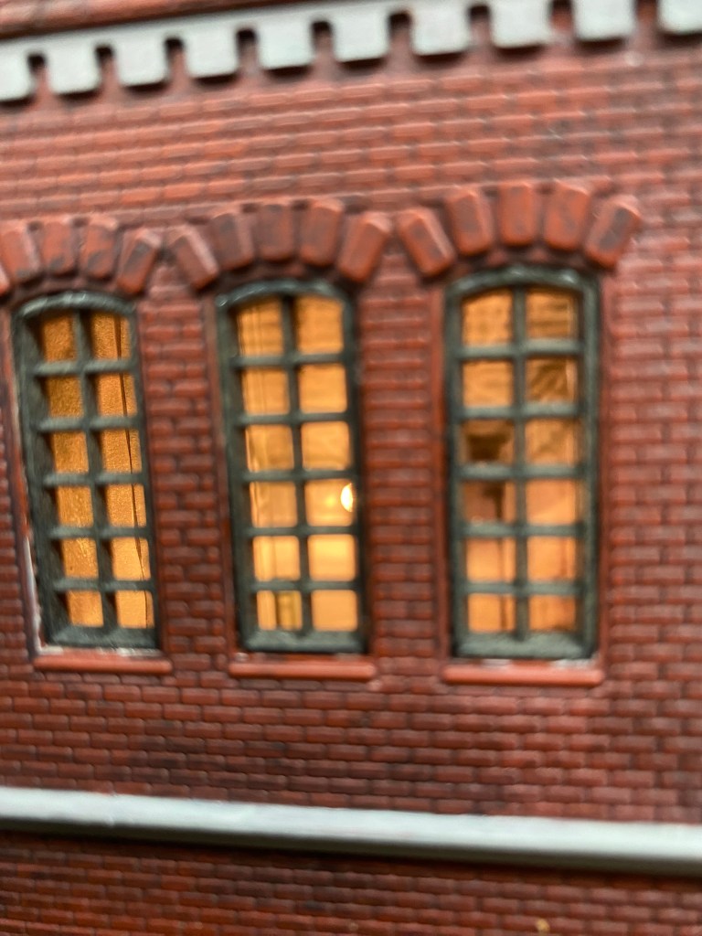 Lights are on inside the Maple Valley Manufacturing Plant, with the interior visible through the windows.