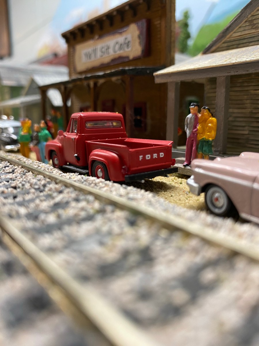 A red pickup is among the cars near the railroad track in front of Ya'll Sit Cafe.