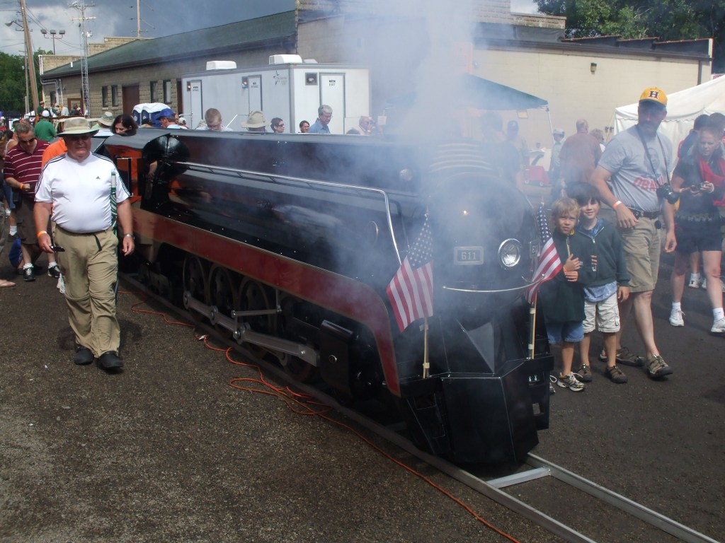 Beautiful small scale steam locomotive with people watching