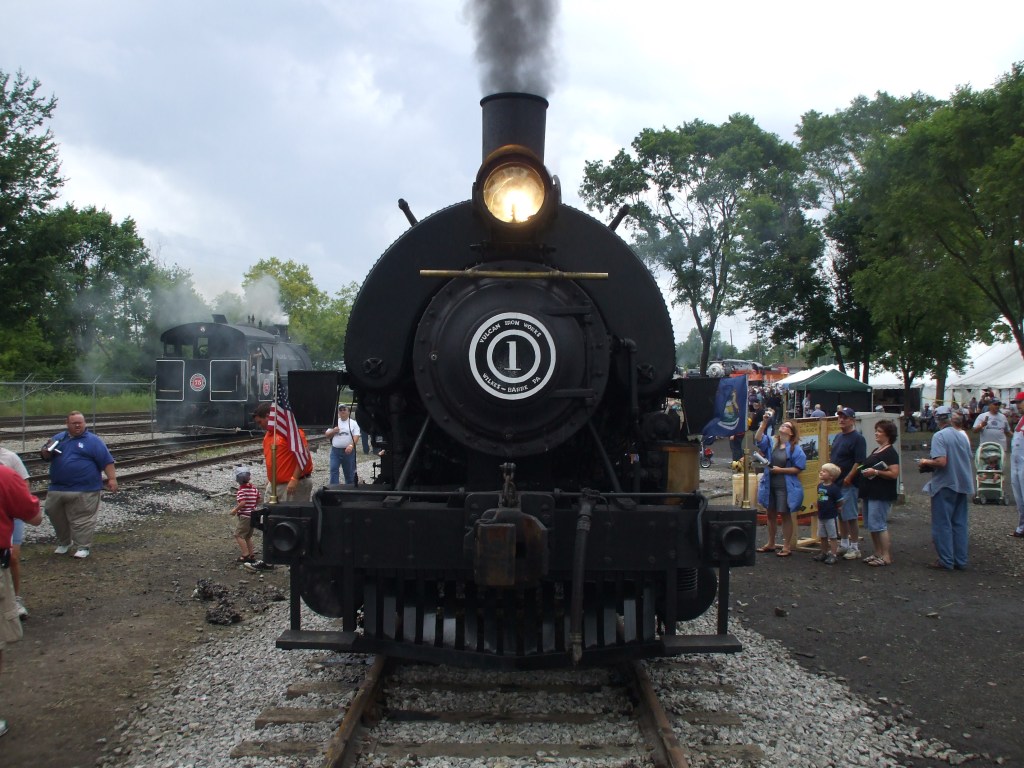 A small 0-4-0 steam engine with steam pouring out
