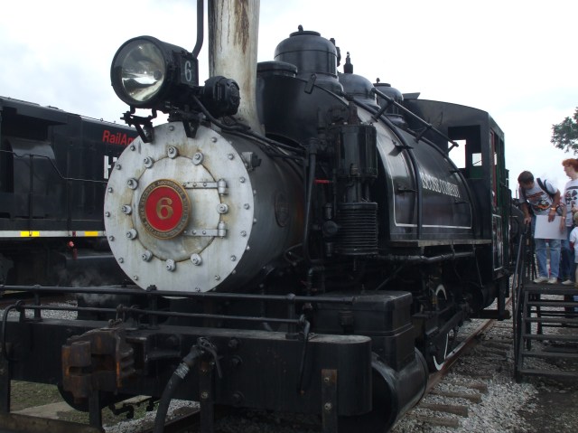 Photo of small steam engine with people looking at it