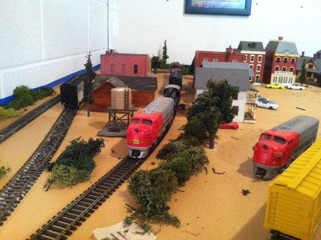 Diesel engines, train cars, trees, buildings