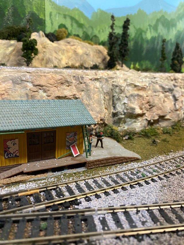 Two tracks at turnout, storage shed, two people, ground cover, rocks
