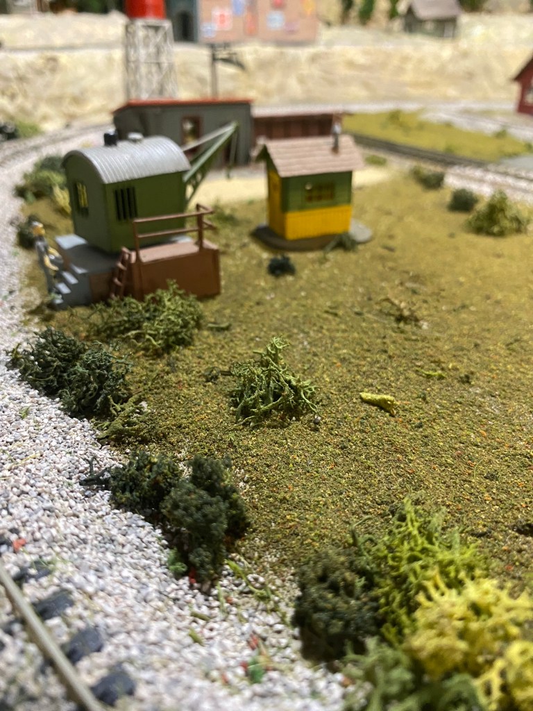 Track with scenery, crane, sheds, ground cover