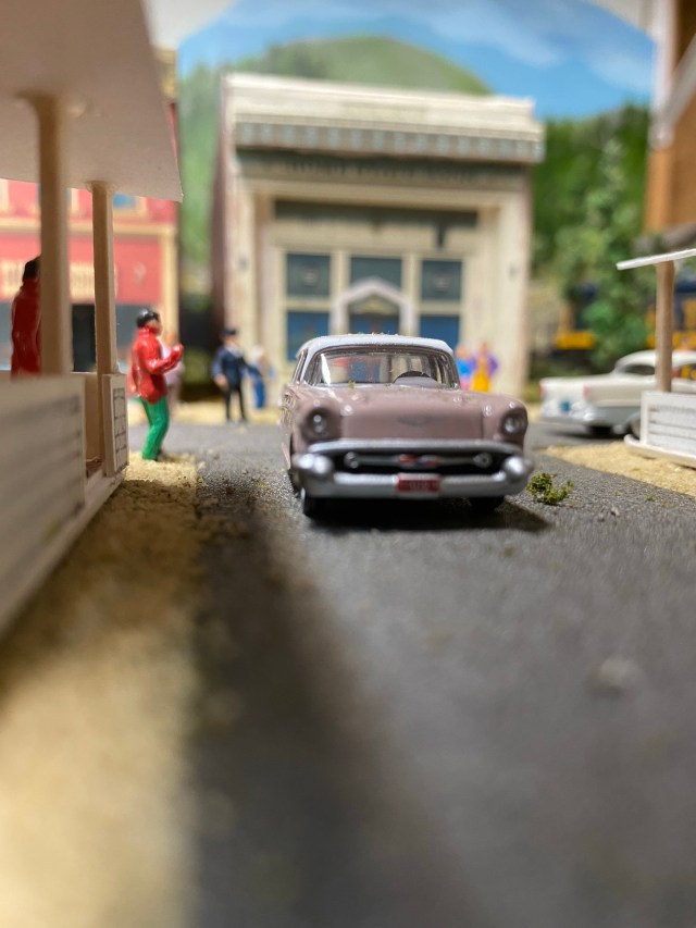 A house, old car, people, buildings, street