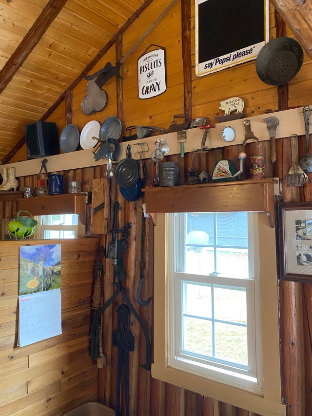 Window, log wall, small antiques hanging on the wall, cabin decor