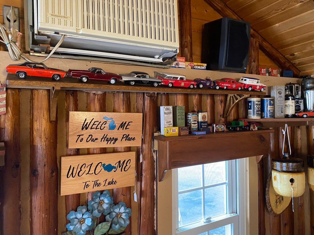 Model cars on a shelf, various antiques, window, carved wooden signs