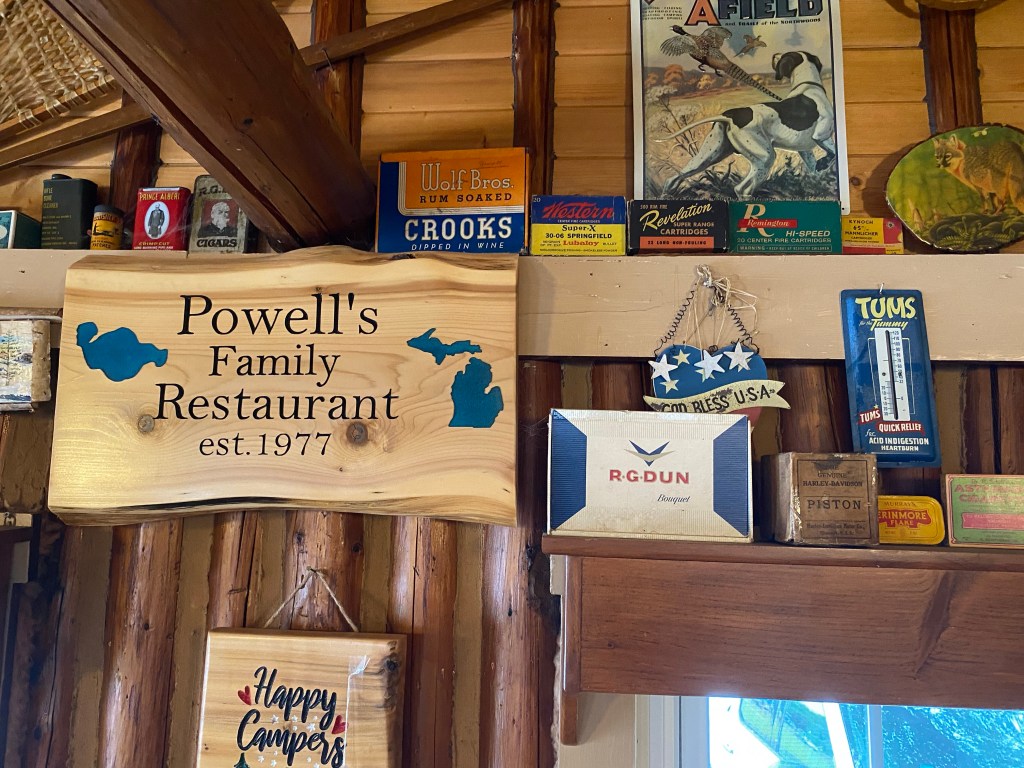 Wooden Powell's sign, antiques, vintage cigar box, log wall