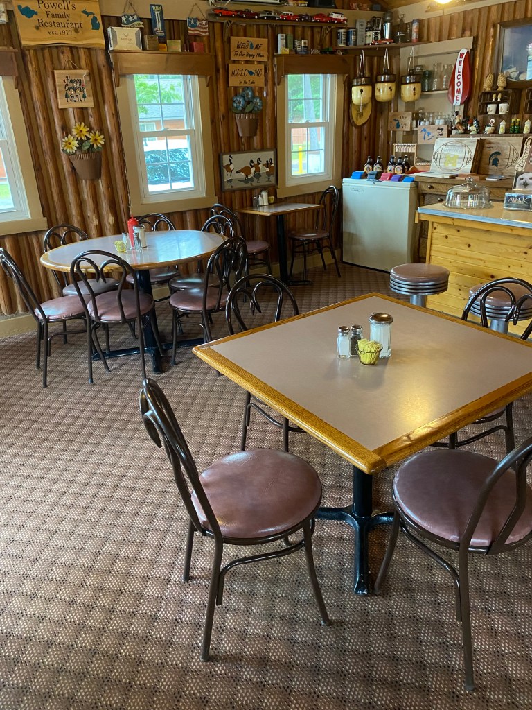 Tables, chairs, log walls, cabin decor, carpeting