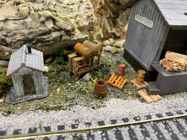 Shed, train track, pallets, tanks, building, rocks