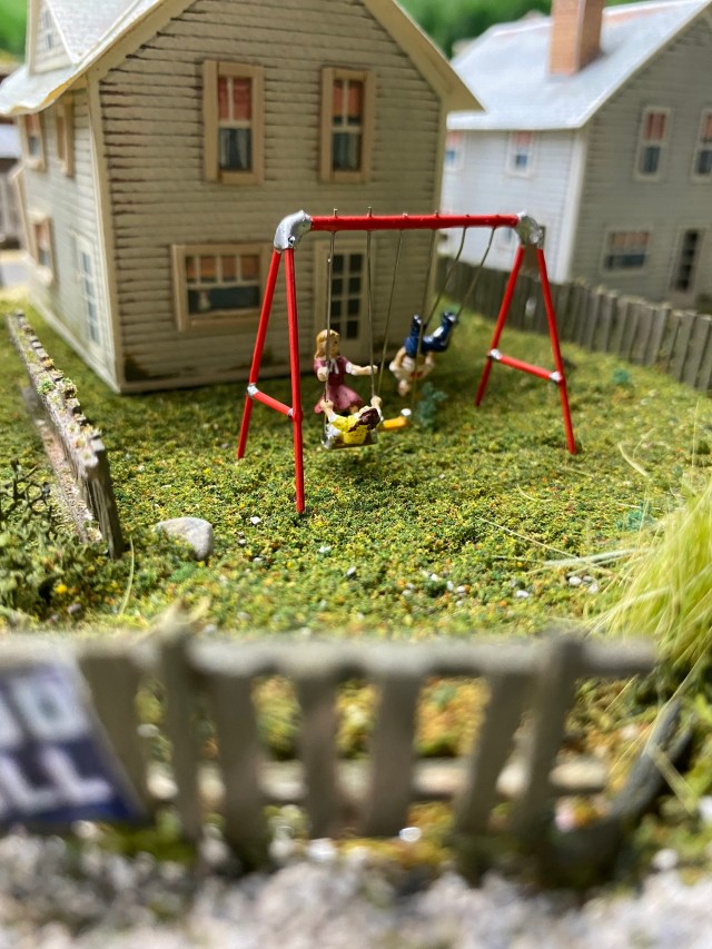 Backyard swing set, children, house, fences, grass