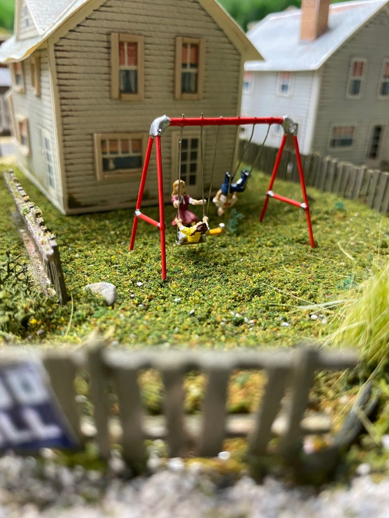 Backyard swing set, children, house, fences, grass