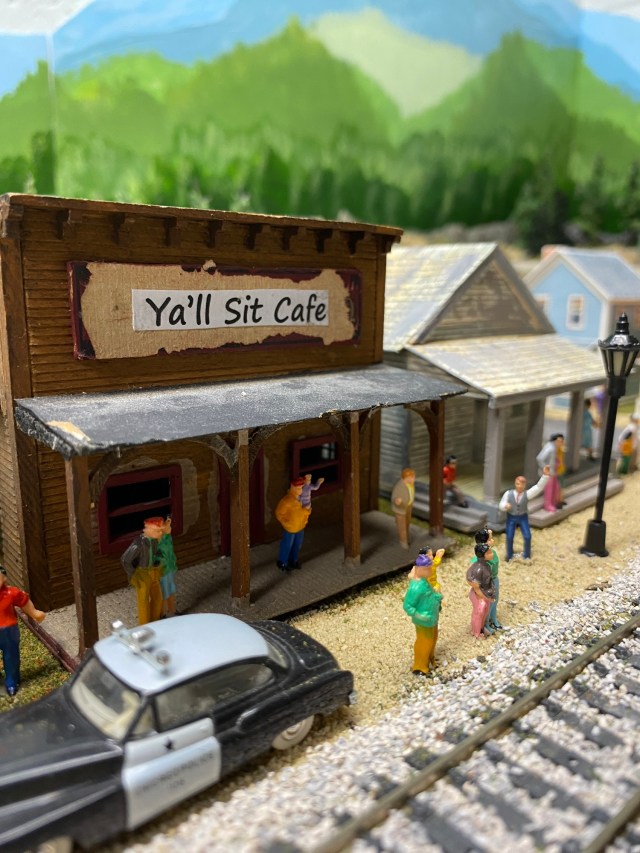 Cafe, people, houses, police car, train track
