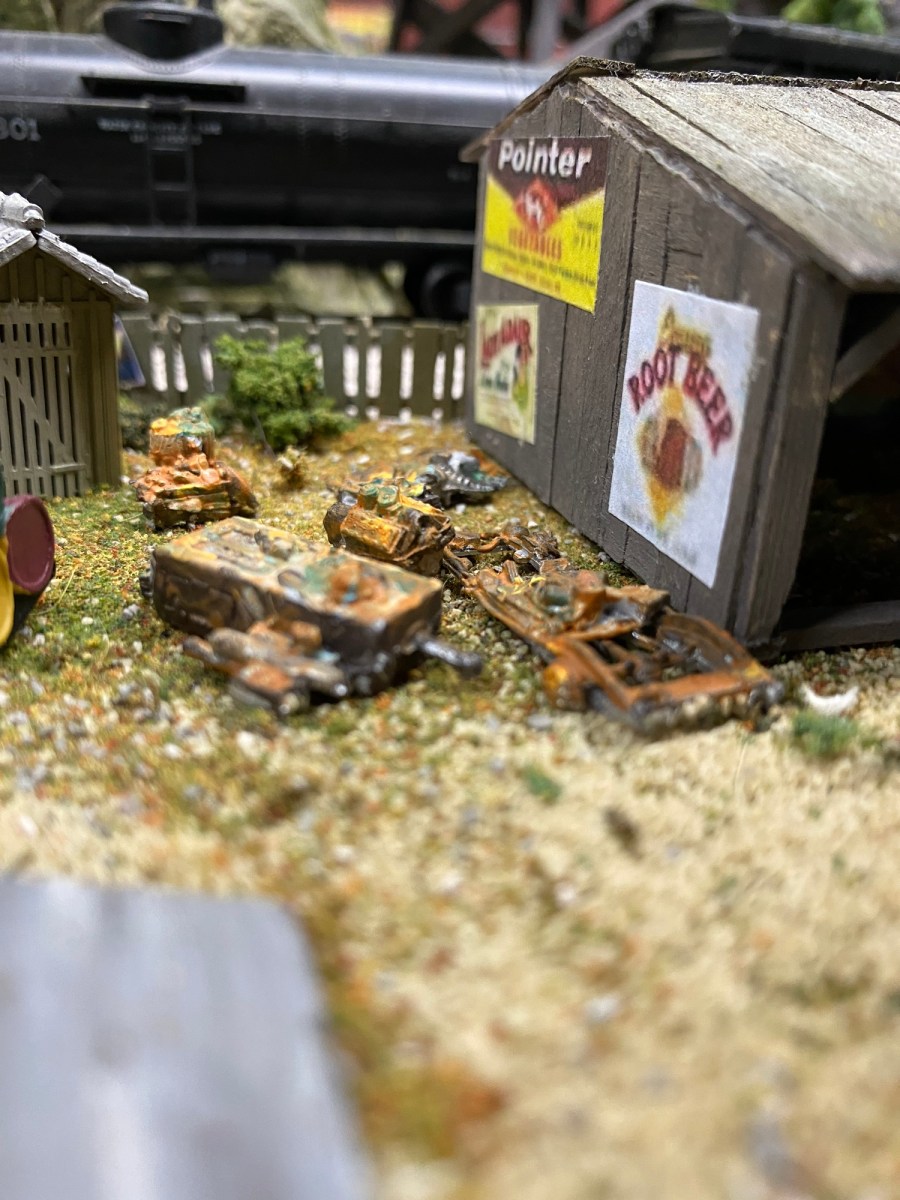Rusting junk, shack, train car, fence