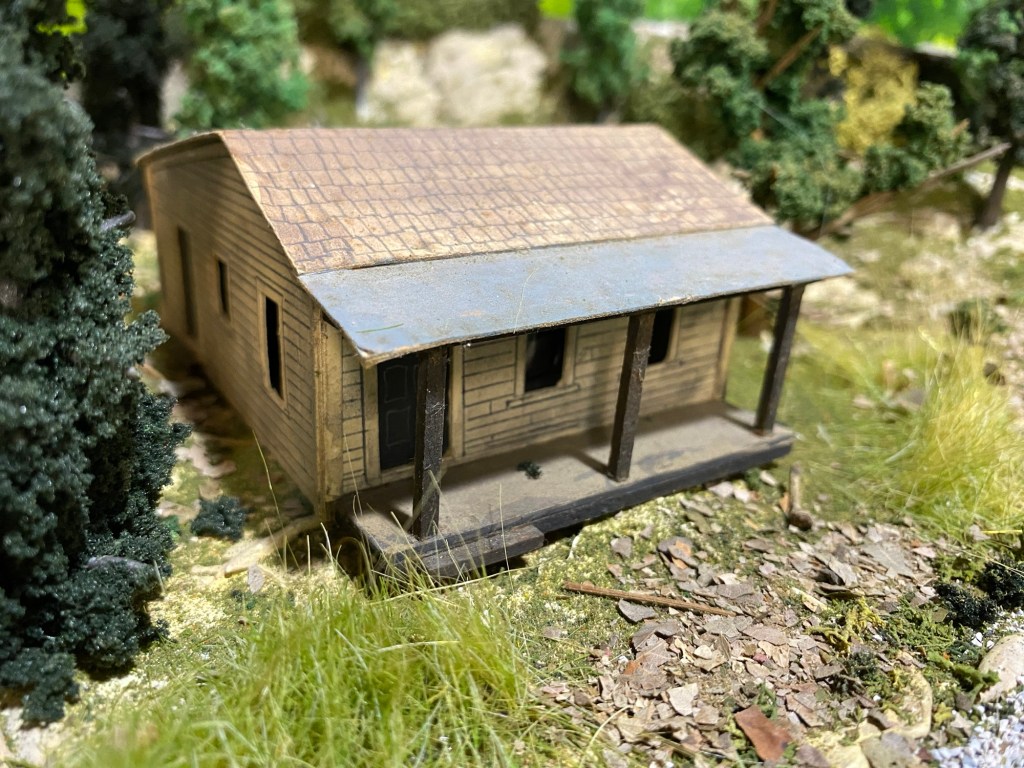 Scratch built cabin, weeds, trees, rocks