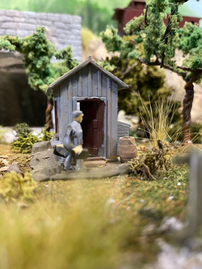 Worker, shed, weeds, trees, tunnel portal,