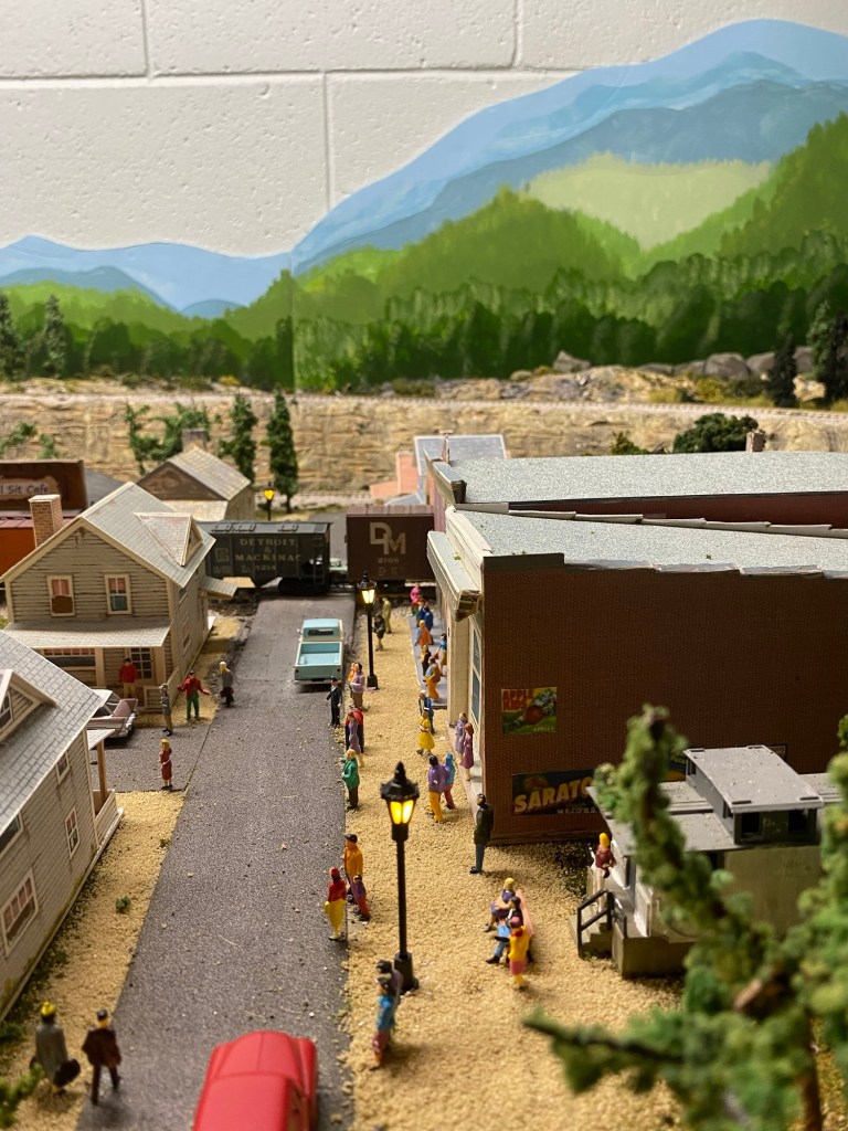 Maple Valley, street lights, people, cars, train cars, backdrop paintings, trees